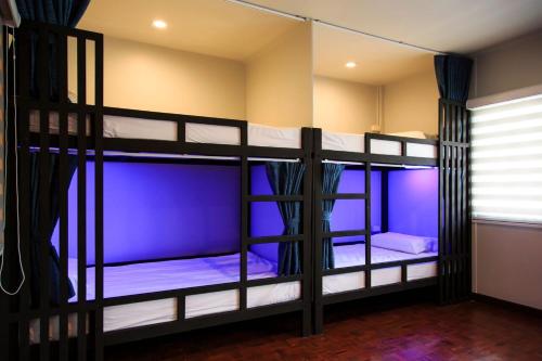 two bunk beds in a room with purple lighting at T2 Hostel Thappraya 12 in Pattaya South