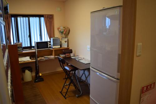 a kitchen with a refrigerator and a microwave at Daiya Ryokan in Kyoto