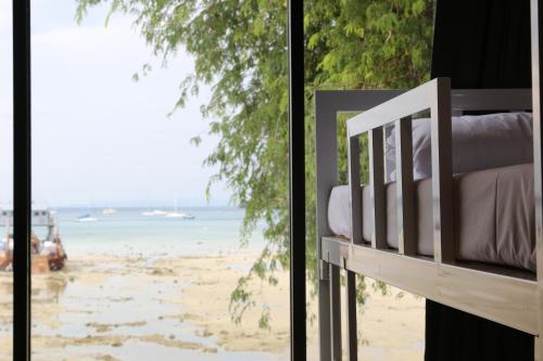 a bedroom with a view of the beach from a window at Ibiza House Phi Phi in Phi Phi Don