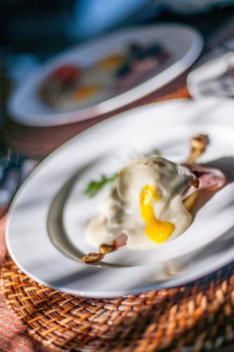 a egg on a white plate on a table at Elephant Hide of Knysna Guest Lodge in Knysna