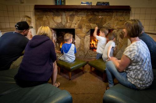 a group of people sitting in front of a fireplace at Daylesford Holiday Park in Daylesford