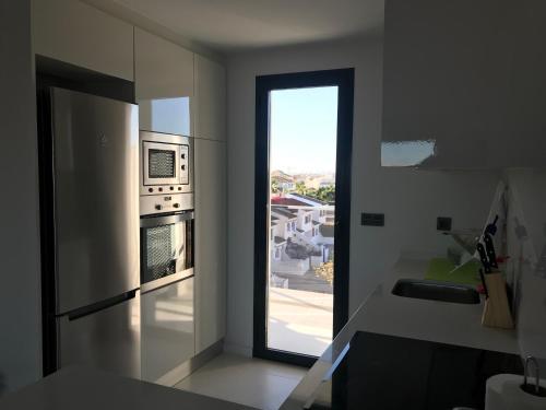 eine Küche mit Blick auf eine Küche mit Fenster in der Unterkunft Bioko II Mil Palmeras in Pilar de la Horadada