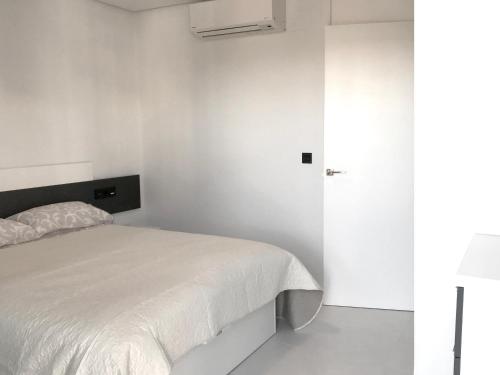 ピラール・デ・ラ・オラダダにあるBioko II Mil Palmerasの白い壁のベッドルーム1室(白いベッド1台付)