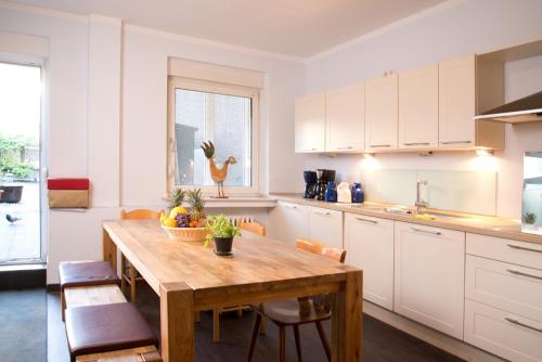 a kitchen with a wooden table and a dining room at Barcelona Bed & Breakfast in Düsseldorf