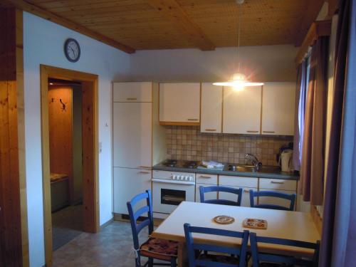 a kitchen with a table and chairs and a kitchen with white cabinets at Apartment Krobath in Murau
