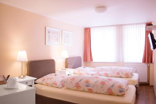 a hotel room with two beds and a window at Barcelona Bed & Breakfast in Düsseldorf