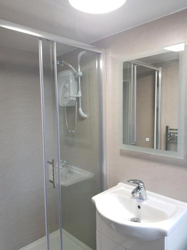 a bathroom with a shower and a white sink at Holly Cottage in Burgh le Marsh