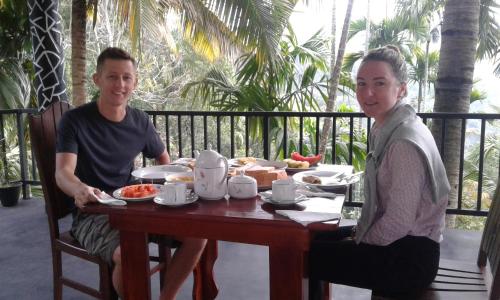 Un hombre y una mujer sentados en una mesa con comida. en Different View, en Ella