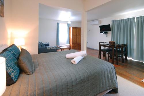 a bedroom with a bed and a living room at Riverview Boutique Motel in Nambucca Heads