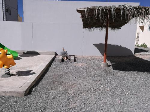 a person sitting on a bench under an umbrella at Salassel Al Jabal Al Akhdar Guesthouse in Al ‘Aqar