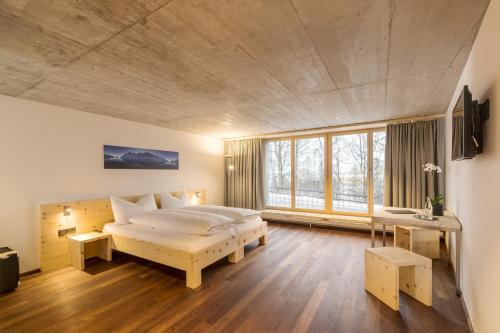 a bedroom with a large bed and a large window at Laagers Hotel Garni in Samedan