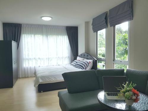 a bedroom with a bed and a couch and a table at D Condo Kathu-Patong Phuket by Jacky in Kathu