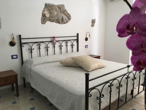 a bedroom with a bed with purple flowers on the wall at Luna D'Agerola in Agerola