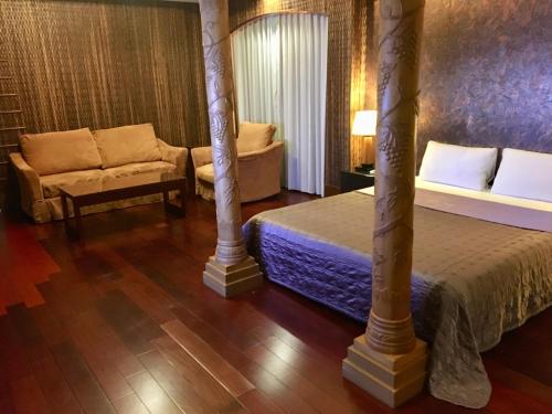 a hotel room with a bed and a couch at New Bale Motel in Bali