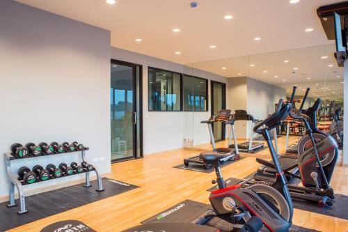 a gym with several treadmills and elliptical machines at Grand Inter Hotel in Samut Sakhon