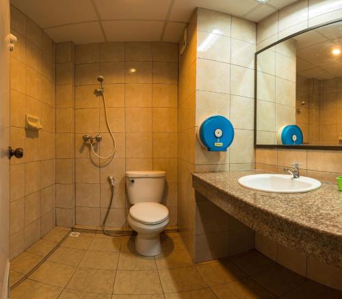 een badkamer met een toilet, een wastafel en een douche bij Sport Inn in Chiang Rai
