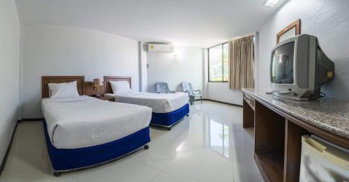 Habitación de hotel con 2 camas y TV en Sport Inn, en Chiang Rai