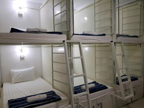 three bunk beds with ladders in a room at Lucky Hostel in Battambang