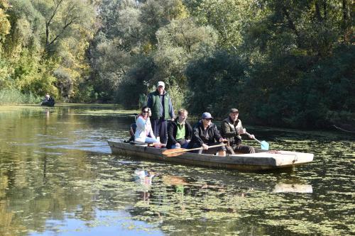 a group of people in a canoe on a river at Bence Apartman in Tiszabábolna