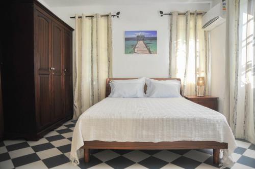 a bedroom with a bed and a checkered floor at koeuris apartment in La Gaulette
