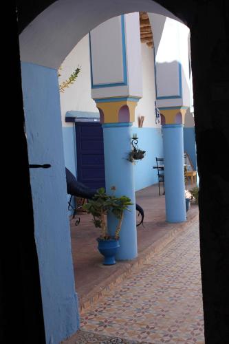 a hallway with blue columns and a potted plant at Escale Rando Taliouine in Taliouine