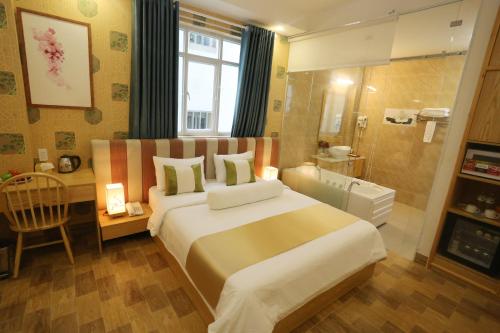a bedroom with a large bed and a bathroom at Thuy Sakura Hotel & Serviced Apartment in Ho Chi Minh City