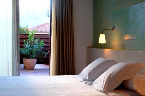1 dormitorio con 1 cama con lámpara y ventana en Hotel Carmen, en Roses