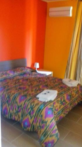 a bedroom with a bed with a colorful comforter at Bed Relax Etnaview in Zafferana Etnea