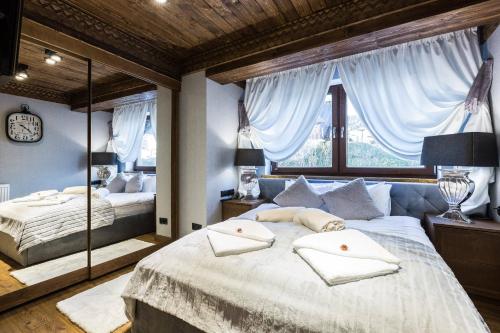 1 dormitorio con 2 camas y ventana grande en Apartament Szymaszkowa Relax Ski Odkryj Zakopane, en Zakopane