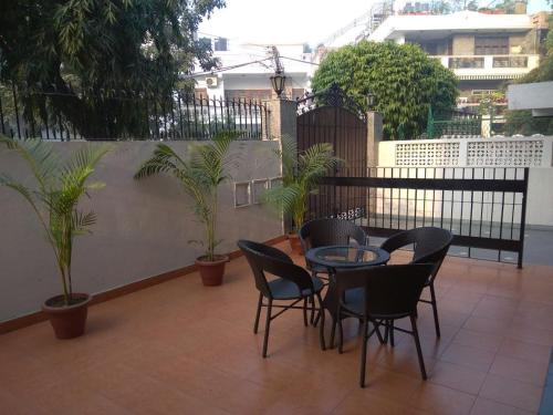 a patio with a table and chairs and plants at The Neem in New Delhi