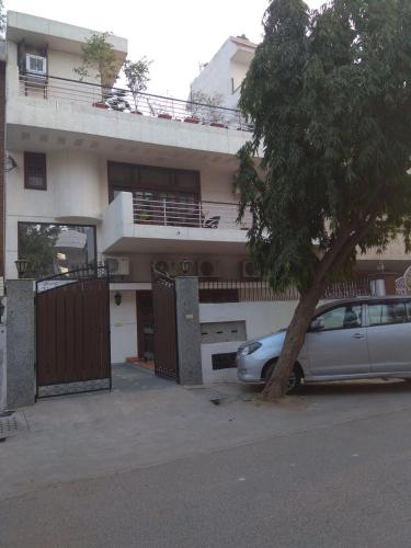 a car parked in front of a house with a tree at The Neem in New Delhi