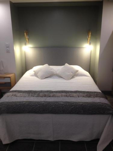 une chambre avec un grand lit blanc avec deux oreillers dans l'établissement grand studio des rivages cathares, à Carcassonne