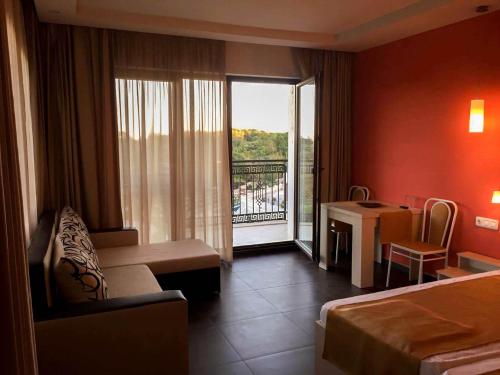 a hotel room with a bed and a desk and a balcony at Studio Elegance in Golden Sands