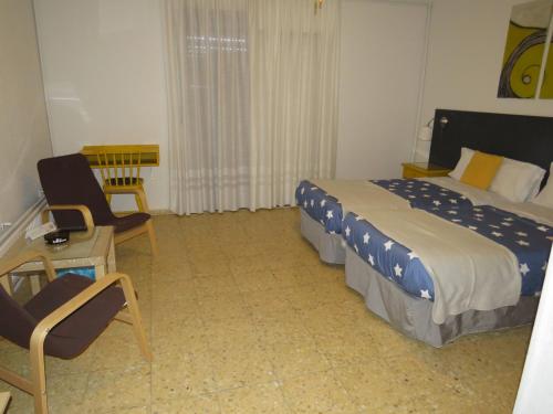 a hotel room with a bed and a chair at Hostal San José in Cadalso de los Vidrios