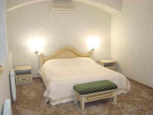 a bedroom with a white bed and two night stands at Veles Hotel in Dnipro