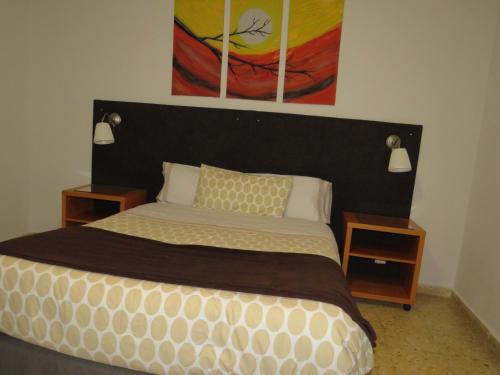 a bedroom with a large bed with two night stands at Hostal San José in Cadalso de los Vidrios