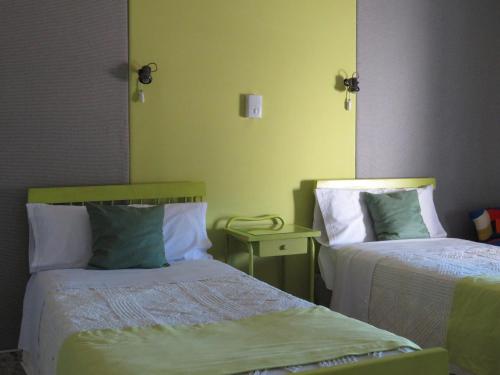 a bedroom with two beds and a mirror on the wall at Hostal San José in Cadalso de los Vidrios