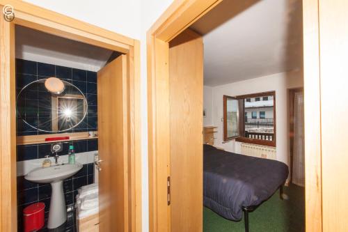 - une petite chambre avec un lit et un lavabo dans l'établissement Breuil Cervinia Funicular House with Private Garage, à Breuil-Cervinia