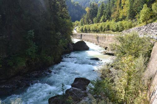 a river with rocks and a bridge in the background at Apartma & savna Slapnik in Luče