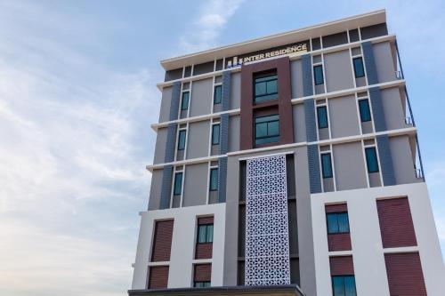 a tall building with a sign on it at Grand Inter Hotel in Samut Sakhon