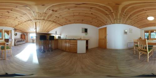 a kitchen and living room with a wooden ceiling at Apartma & savna Slapnik in Luče