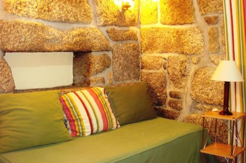 a stone wall with a bench with two pillows at Quinta Do Crestelo Aparthotel in Seia