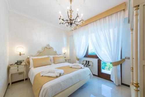 a bedroom with a bed and a chandelier at B&B Palazzo Montesanto in Maiori