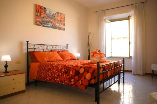 a bedroom with a bed with orange sheets and a window at Linda Musei Vaticani in Rome