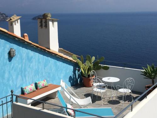 balcone con tavolo, sedie e vista sull'oceano di Paradiso Di Manù a Noli