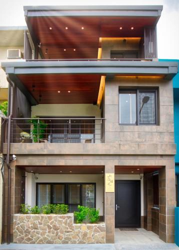 a house with a porch and a balcony at The Sunbeam Hideaway B&B in Luodong