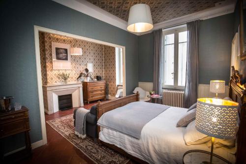 a bedroom with a large bed and a fireplace at Carcassonne Townhouse in Carcassonne
