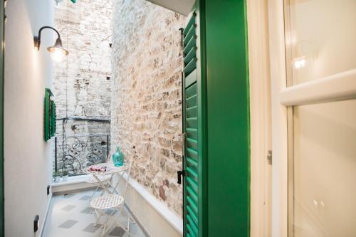 a small bathroom with a green door and a table at Residence Teatro in Šibenik