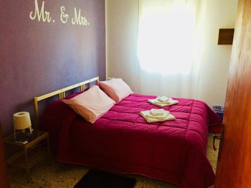 a bedroom with a red bed with towels on it at I Colori degli Agrumi Holiday Home in Floridia