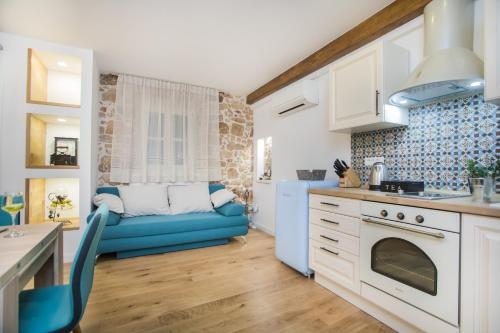 a kitchen and living room with a blue couch at Residence Teatro in Šibenik